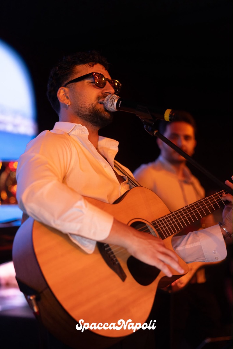 Cantante e chitarrista della band SpaccaNapoli mentre canta al microfono